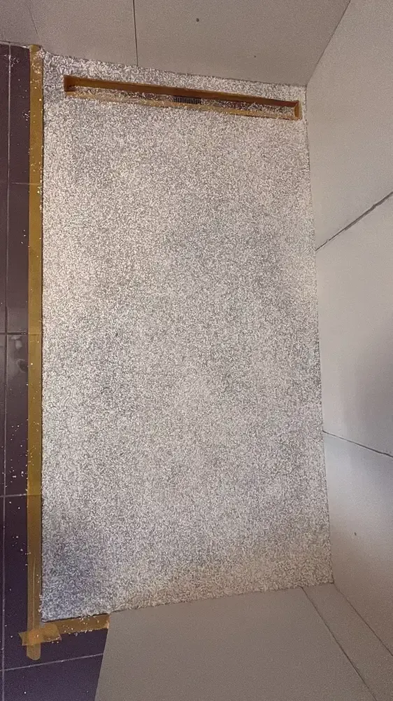 Receveur de douche en gravier de pierre scellé avec caniveau en haut, salle de bain en cours de travaux